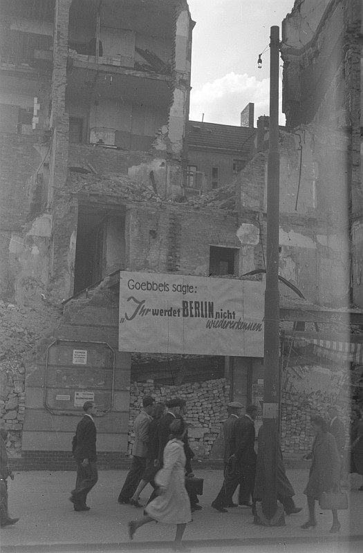 Straßenszene mit Passanten vor Ruinenfassade mit Transparent "Goebbels sagte: 'Ihr werdet Berlin nicht wiedererkennen"' © Deutsche Fotothek / Abraham Pisarek
